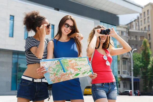 Tres amigas al aire libre con papel mapa de la ciudad — Foto de Stock