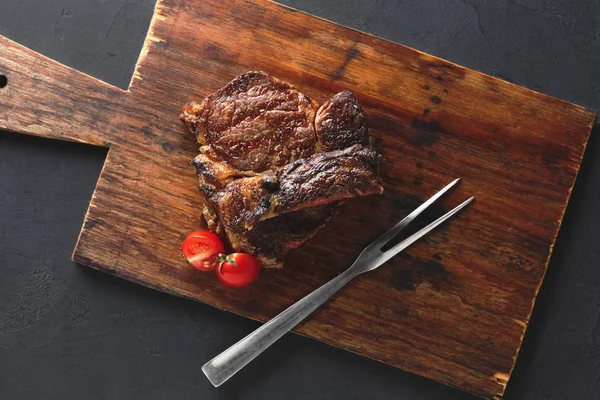 Rib eye steak on wooden board, top view — Stock Photo, Image