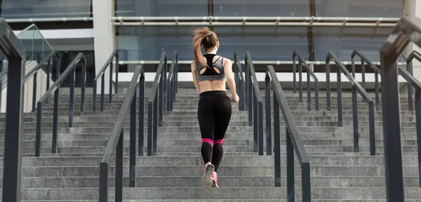 Deportiva mujer corriendo en las escaleras del estadio — Foto de Stock