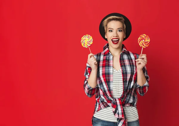 Happy casual fille avec des sucettes rayées à fond rouge — Photo