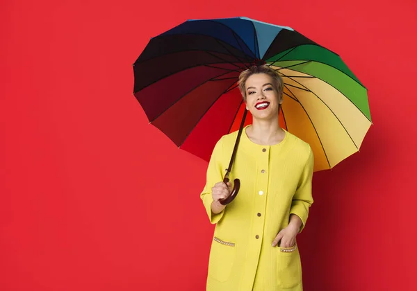 Chica feliz en abrigo amarillo posando en fondo rojo —  Fotos de Stock