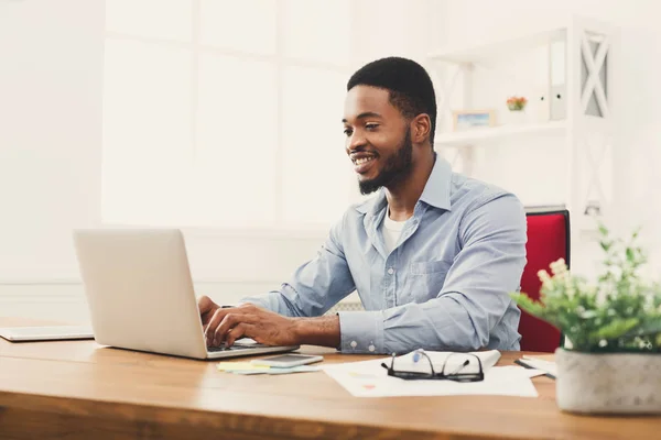 Ung svart affärsman arbetar med laptop — Stockfoto