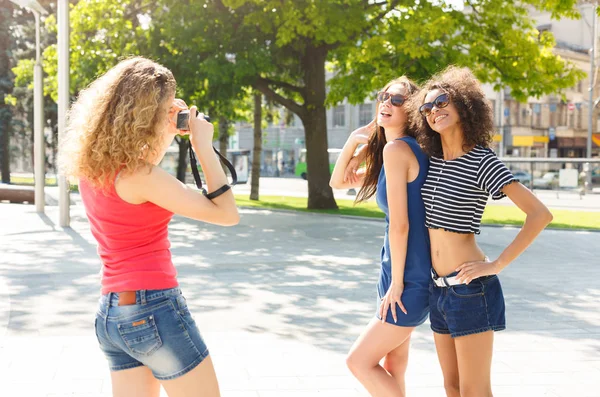 Happy girls with camera outdoors in the city — Stock Photo, Image