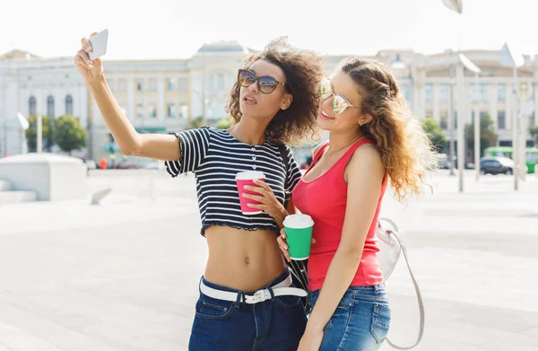 Счастливые девушки со смартфоном на открытом воздухе в парке — стоковое фото