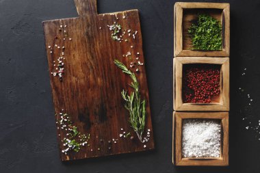 Ahşap masa ve koyu arka plan üzerinde çeşitli baharatlar