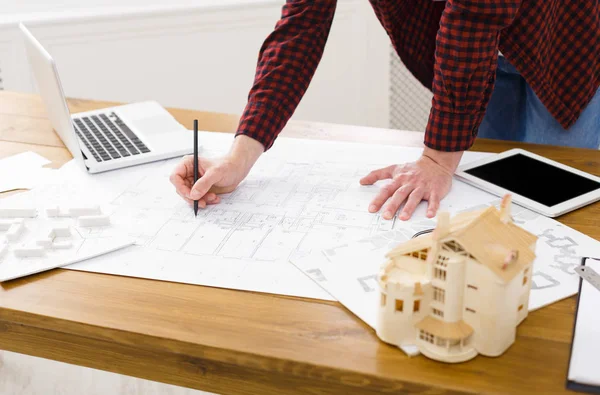 Young architect working with blueprints in the office — Stock Photo, Image