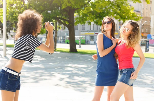 Happy girls with camera outdoors in the city — Stock Photo, Image