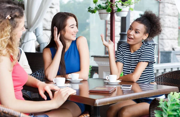 Happy girls sitting in the cafe and talking Royalty Free Stock Photos