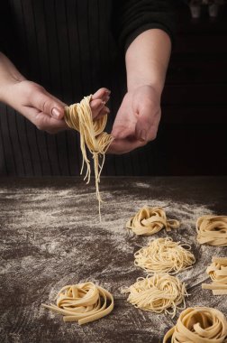 Kadın yapımı tagliatelle yuva mutfak masasında