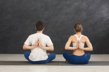 Yoga sınıfındaki genç çift geri germe