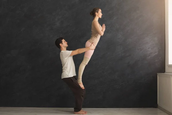 Junges Paar übt gemeinsam Akroyoga auf Matte — Stockfoto