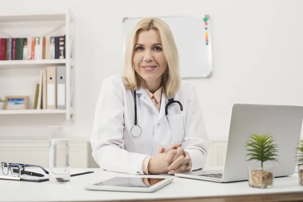 Retrato de médica sentada na área de trabalho — Fotografia de Stock