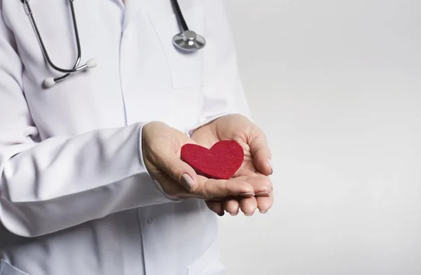 Taking care of heart. Doctor holding red heart — Stock Photo, Image