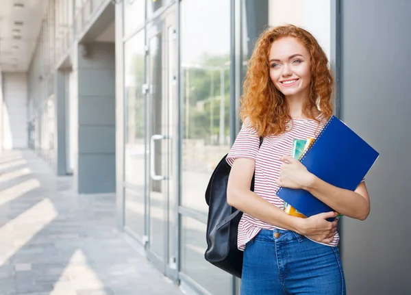 Jonge roodharige vrouwelijke student op weg naar klassen met rugzak, laptops — Stockfoto
