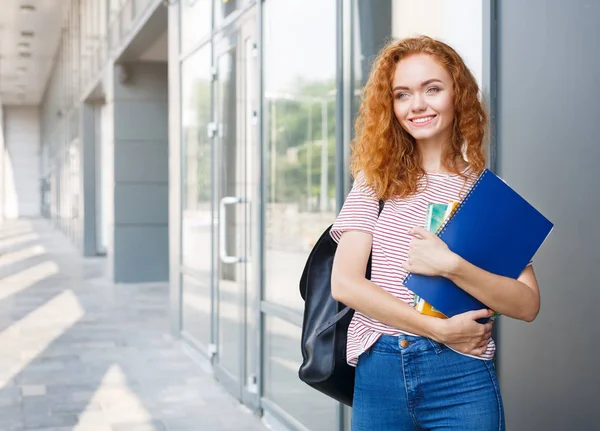 Joven pelirroja estudiante de camino a clases con mochila, cuadernos — Foto de Stock