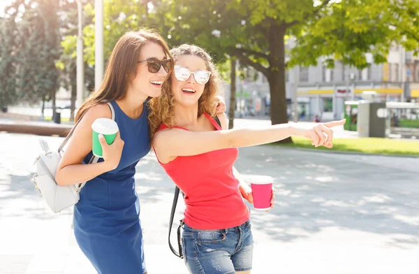 Happy girls with take away coffee outdoors — Stock Photo, Image