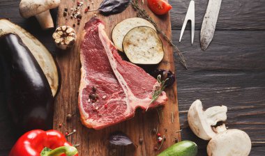 Ahşap tahta üzerinde sebze ile ham t-bone biftek