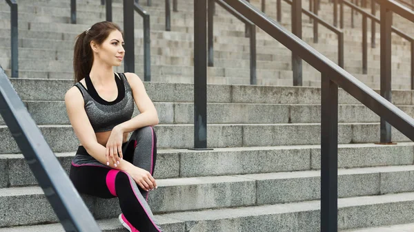 Tired slim woman relaxing on stairs — Stock Photo, Image