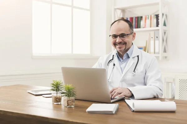 Portrait of doctor in glasses sitting at desktop — Stock Photo, Image