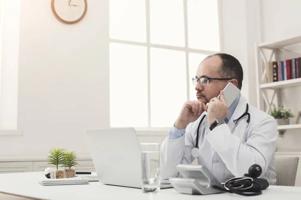 Serious doctor talking on phone with his patient — Stock Photo, Image