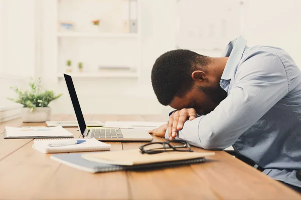 Спящий перегруженный черный бизнесмен с ноутбуком — стоковое фото