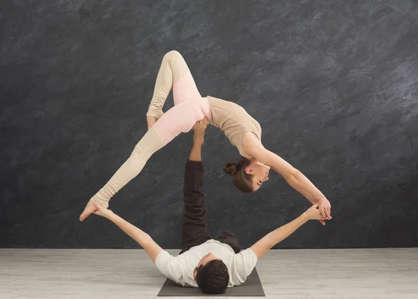 Junges Paar übt gemeinsam Akroyoga auf Matte — Stockfoto