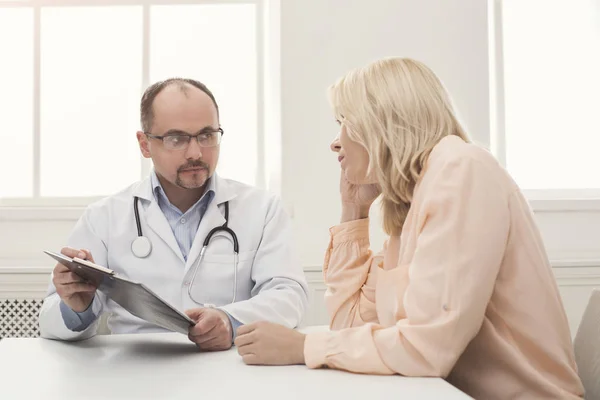 Doctor consulting woman in hospital — Stock Photo, Image