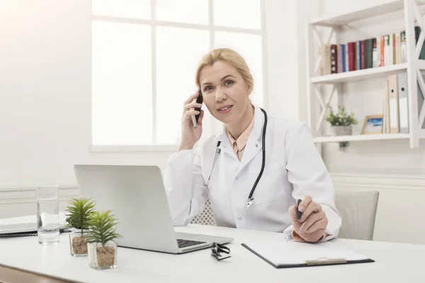 Médecin attrayant parlant au téléphone avec le patient — Photo