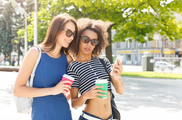Happy female friends with smartphone outdoors — Stock Photo, Image
