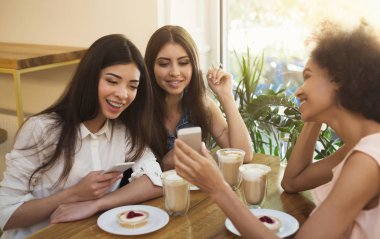 Café'de eğlenmek ve akıllı telefonlar kullanarak kızlar