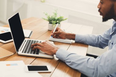 Afrikalı-Amerikalı işadamı dizüstü bilgisayarda yazarak