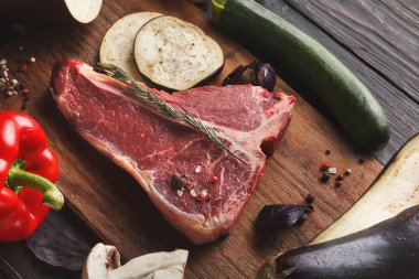 Ahşap tahta üzerinde sebze ile ham t-bone biftek