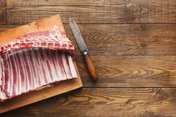 Raw cut rack of lamb on wooden board — Stock Photo, Image