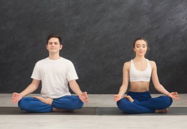 Genç çift birlikte meditasyon yapıyor.