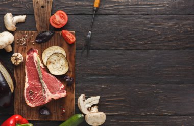 Ahşap tahta üzerinde sebze ile ham t-bone biftek