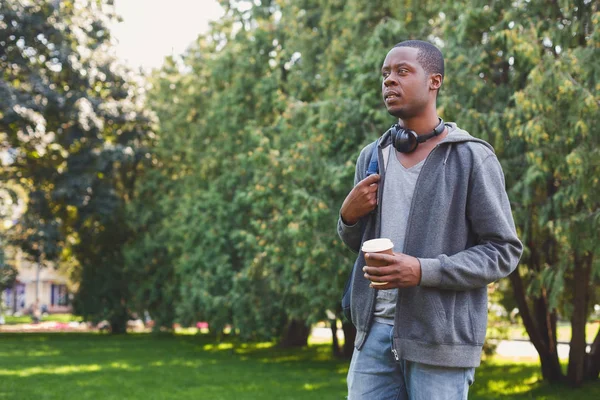 Americký student s odnést kávu v parku venku — Stock fotografie