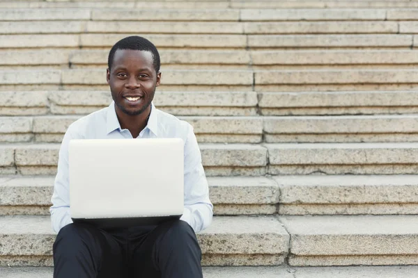 Αφροαμερικανός ευτυχής επιχειρηματίας που εργάζεται με το laptop σε εξωτερικούς χώρους — Φωτογραφία Αρχείου