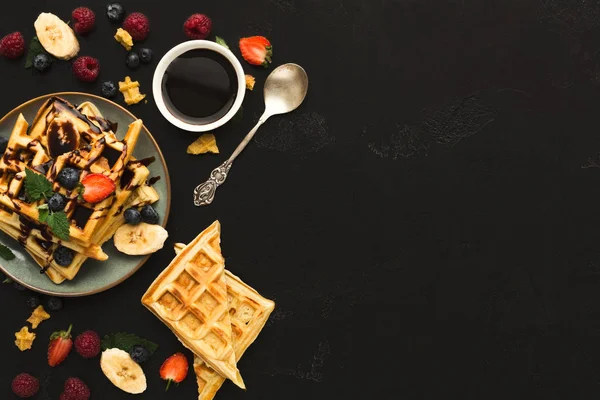 Waffles with fruits, breakfast background top view on black