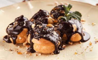 Çikolata sosu ve nane yaprakları ile Fransız profitroles