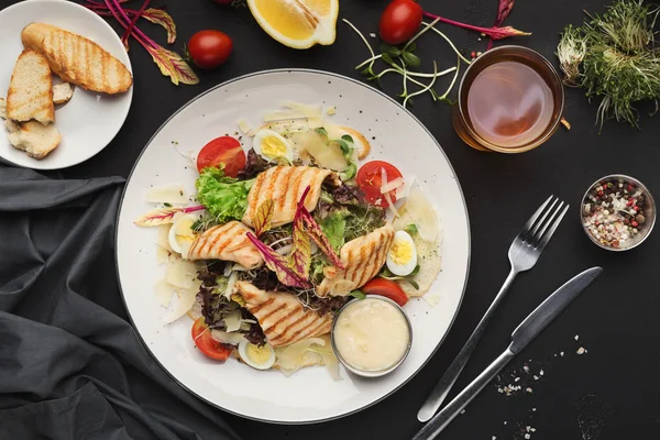 Piatto di insalata Cesare su sfondo nero — Foto Stock