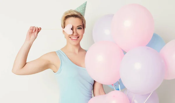 Aniversário menina em chapéu de festa segurando balões — Fotografia de Stock