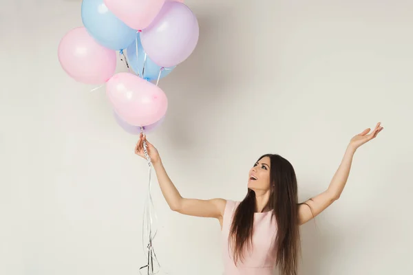 Glad tjej hålla ballonger över vita studio bakgrund — Stockfoto