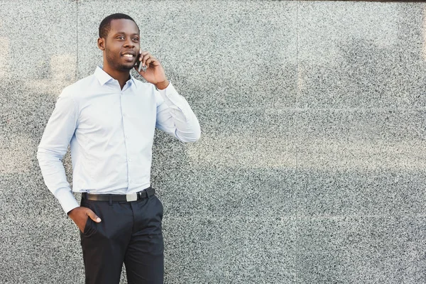 Portrét jistý mladý černý podnikatel mluví na buňku — Stock fotografie