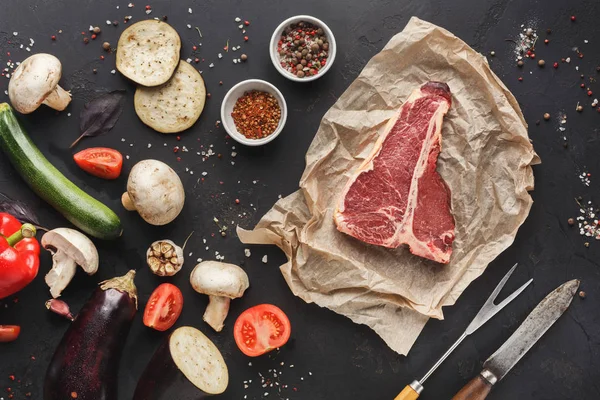 Ahşap tahta üzerinde sebze ile ham t-bone biftek