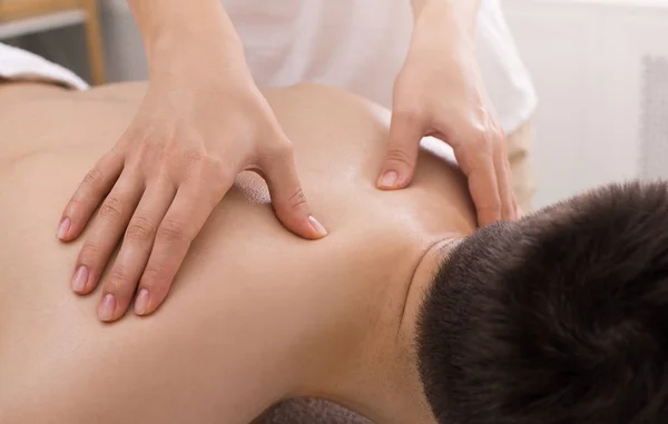 Massagista fazendo massagem nas costas no corpo do homem — Fotografia de Stock