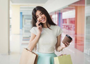 Çarşıda alışveriş yaparken cep telefonu üzerinde konuşurken kadın