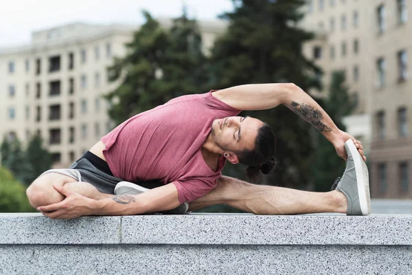 Man doing yoga stretching exercise in the city — Stock Photo, Image