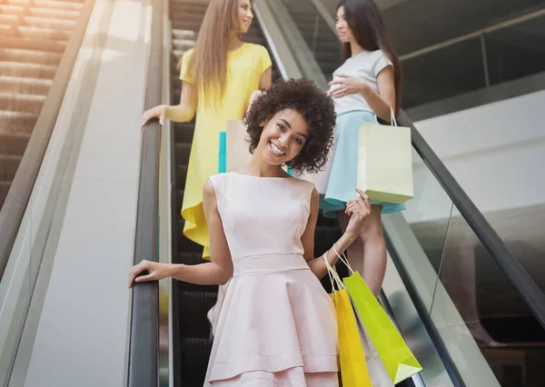 Glada tjejer på rulltrappan i köpcentrum — Stockfoto