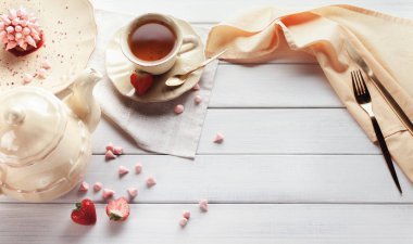 Tabloda çay partisinde pembe tatlı ile ayarla