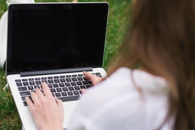 Boş ekran açık havada olan dizüstü bilgisayar üzerinde çalışan kadın